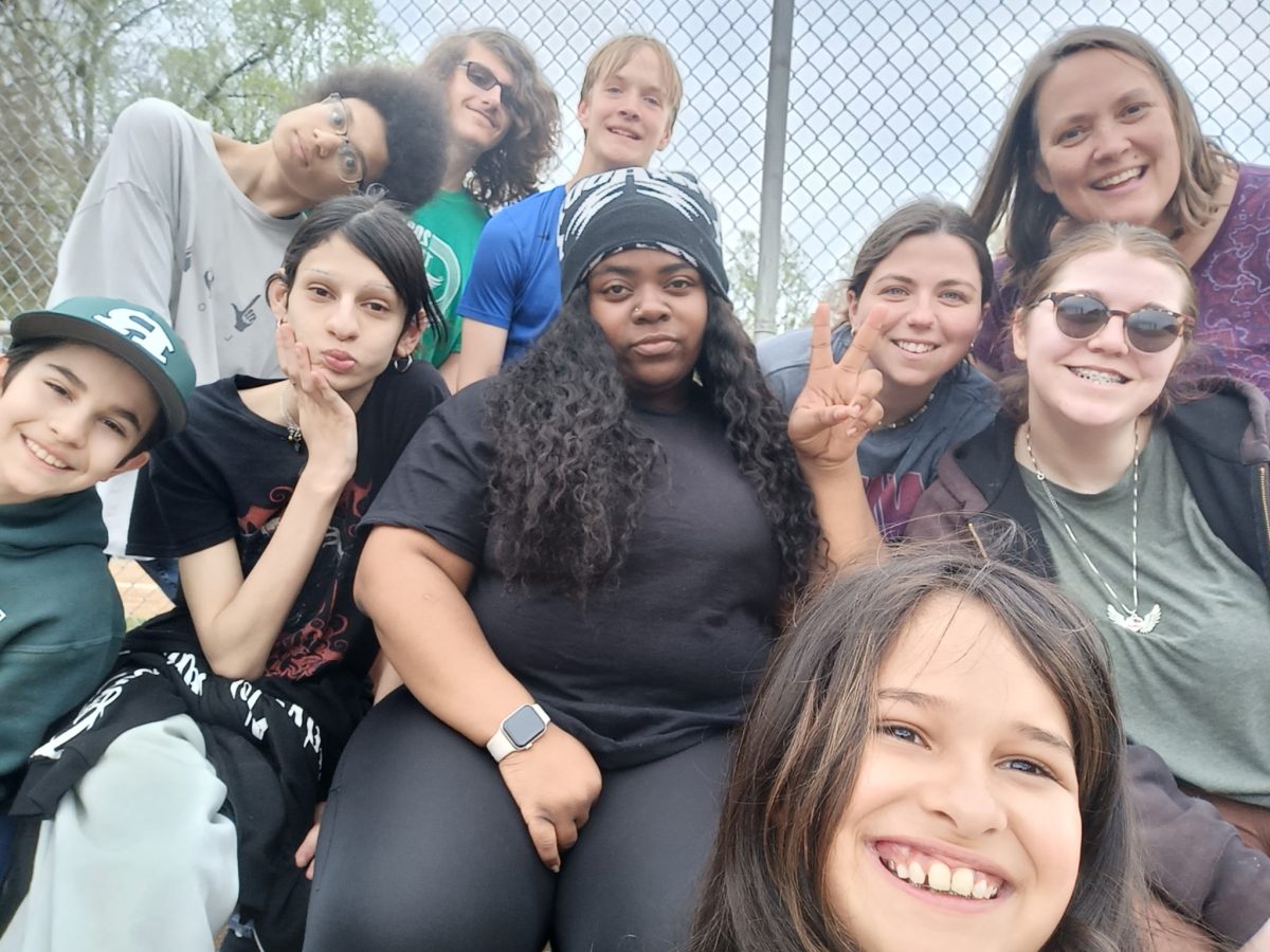 Pastor Amy sits with some of our Youth Group regulars on the bleachers at a local park - the group represents a mix of races, gender identities, faith backgrounds (and levels of enthusiasm).
